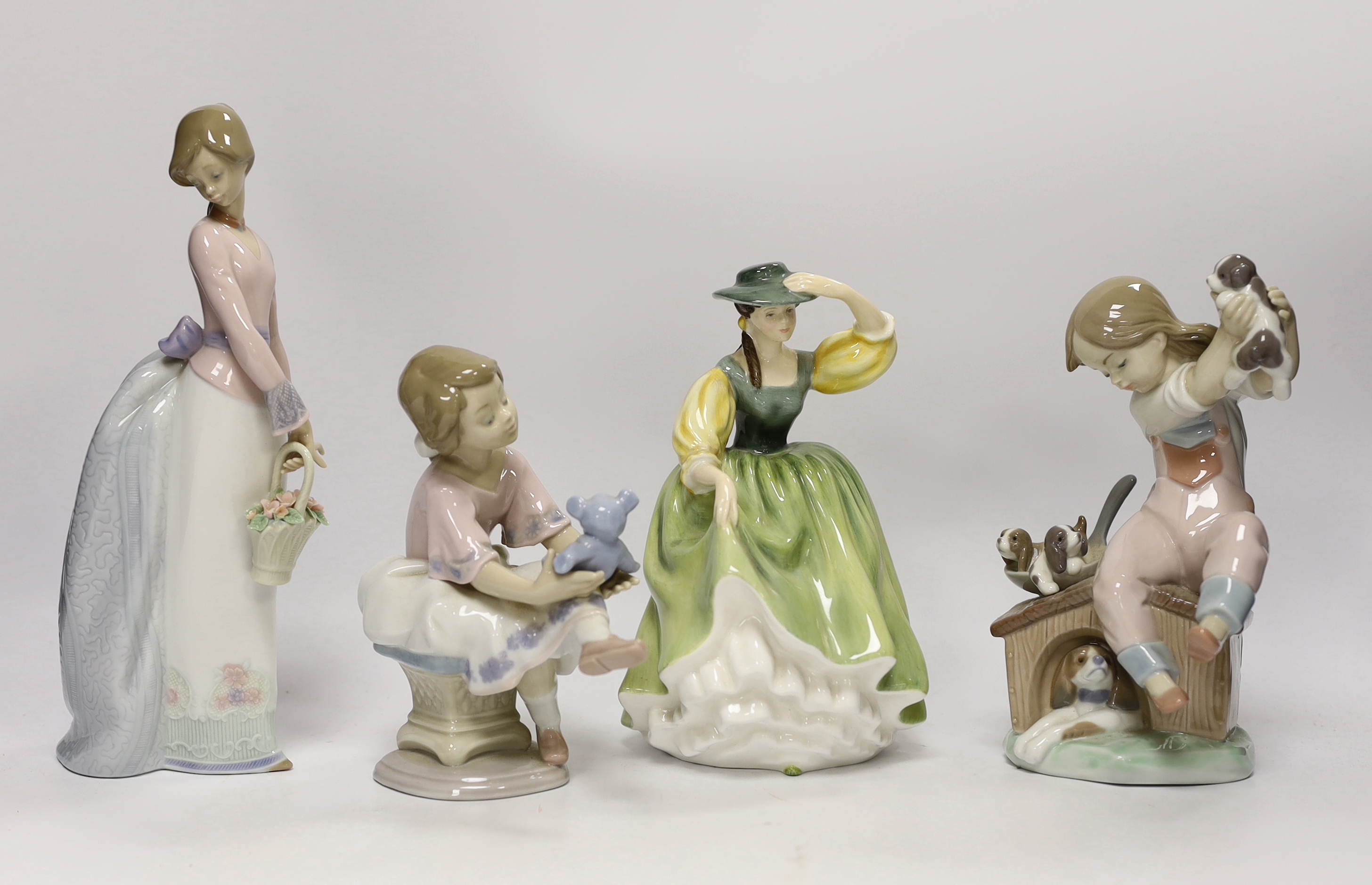 A Lladro recumbent clown, three smaller Lladro figures and a Royal Doulton Buttercup figure, clown 37.7cm wide (5)